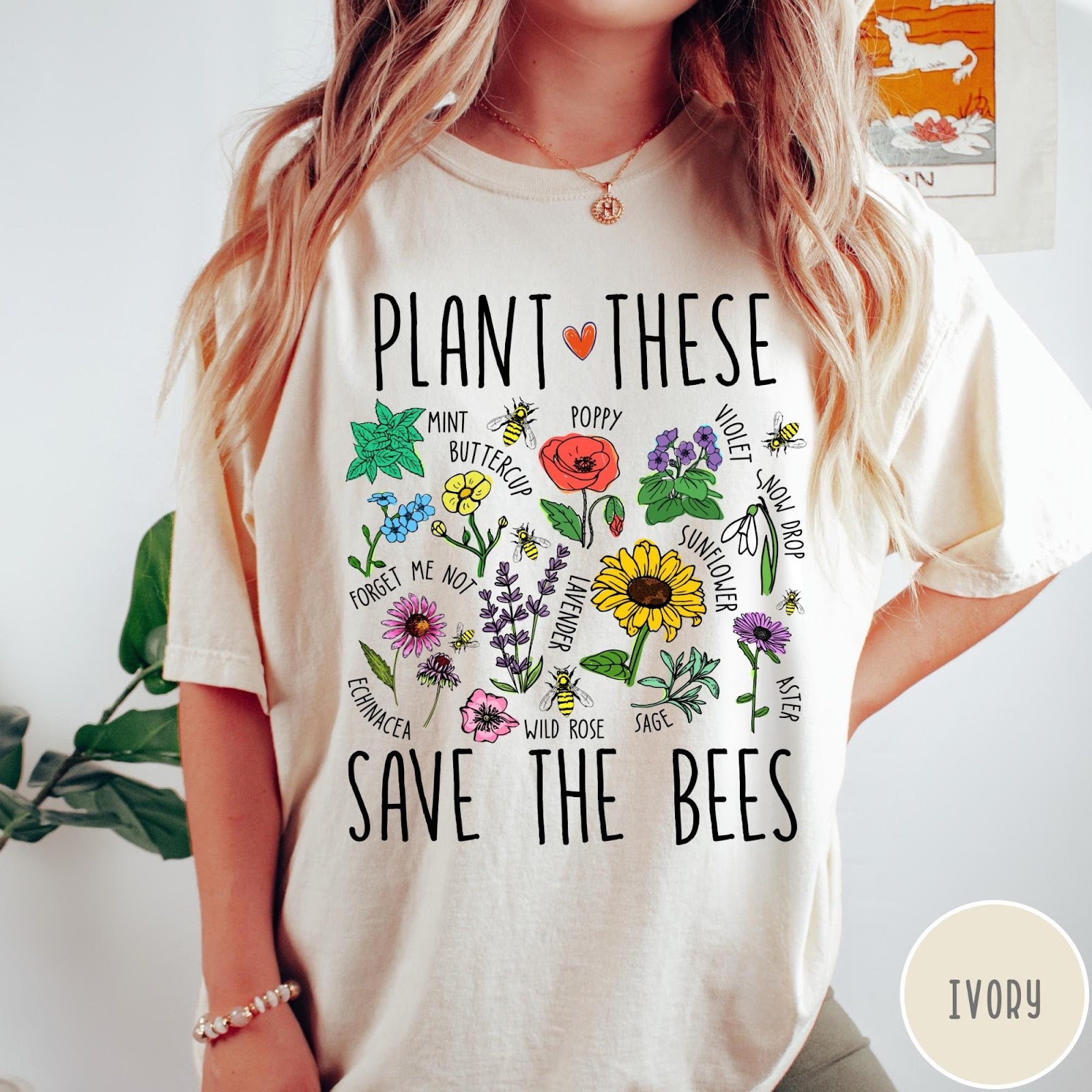 Comfort Colors tee in Ivory featuring botanical garden style graphic with various flowers and bees