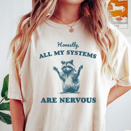 Comfort Colors tee in Ivory featuring graphic illustration of a nervous raccoon with arms raised in air