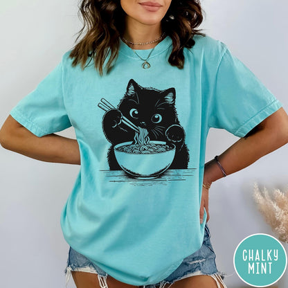 Comfort Colors tee in Chalky Mint featuring graphic illustration of a cute black cat eating a bowl of ramen