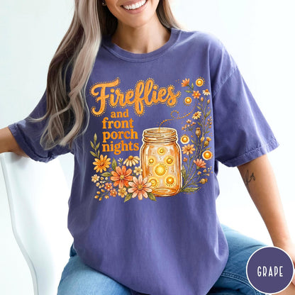 Comfort Colors tee in Grape featuring whimsical graphic design of fireflies in a mason jar with wildflowers