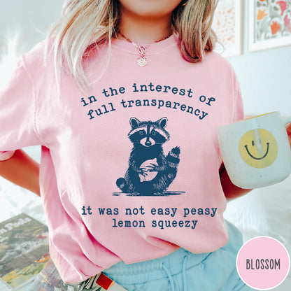 Comfort Colors tee in Blossom featuring screen printed raccoon graphic and text about full transparency and lemons