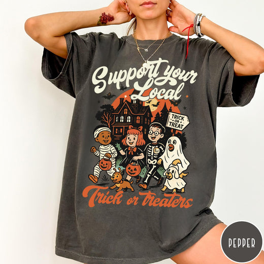 Comfort Colors tee in Pepper featuring vintage style trick or treaters graphic with a haunted house background