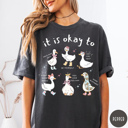 Comfort Colors tee in Pepper featuring cute cartoon geese with encouraging text about mental health and self-care