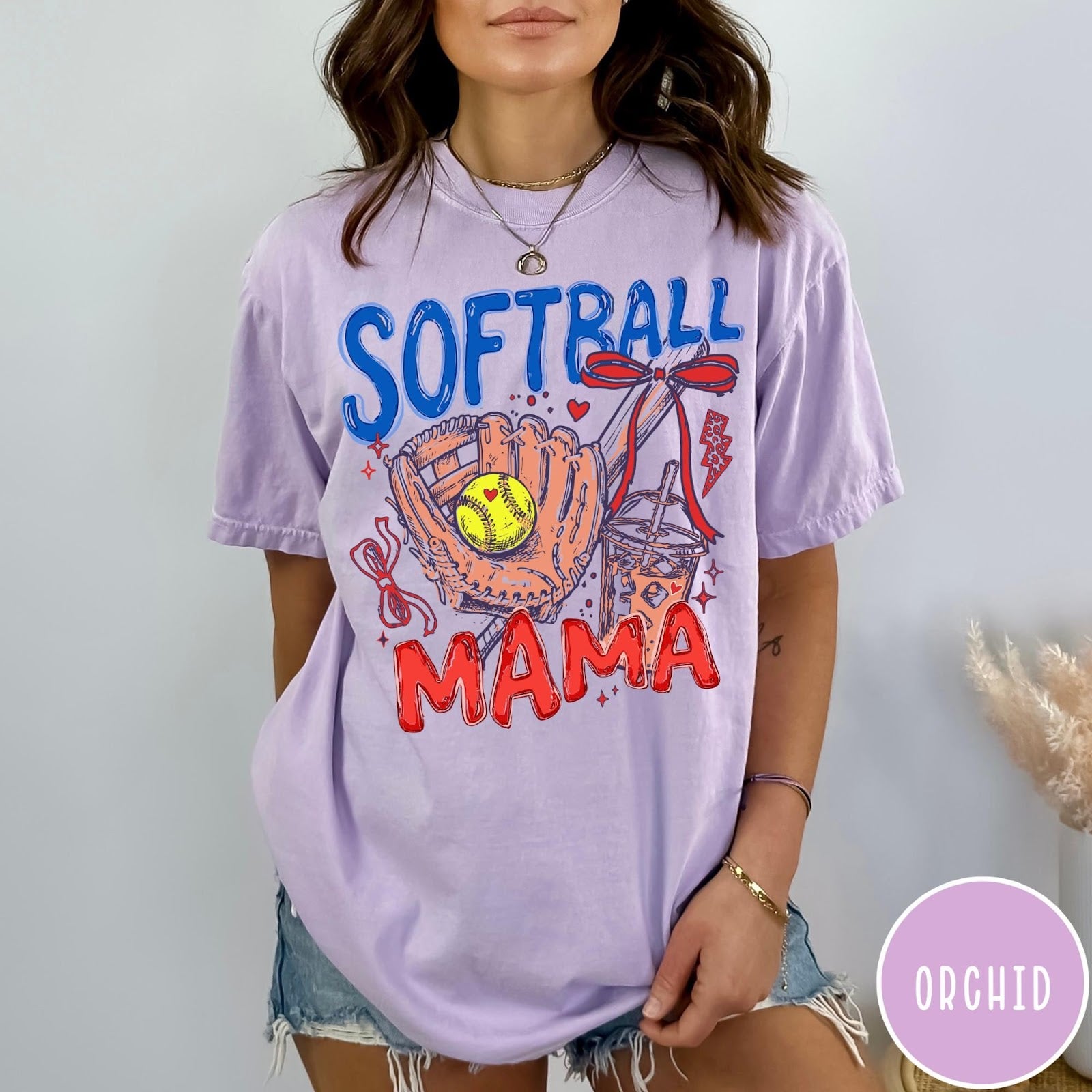 Comfort Colors tee in Orchid featuring softball mom graphic with glove, ball, bat, and iced coffee design